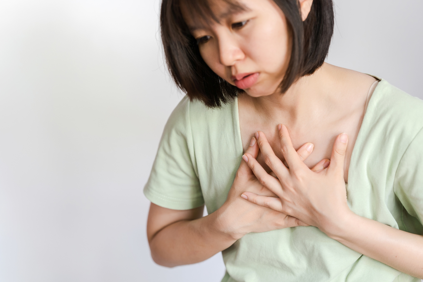 A woman has chest pain. Possible signs of acute myocardial infarction or Heart Attack. Health care concept.